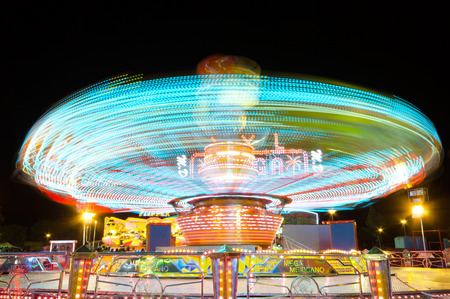 COLLADO VILLABA, SPAIN - JULY, 27: Long eposure picture of a carrusel rotating during the local fair in a small amusement park in Collado Villaba, Spain, on July 27, 2014.のeditorial素材