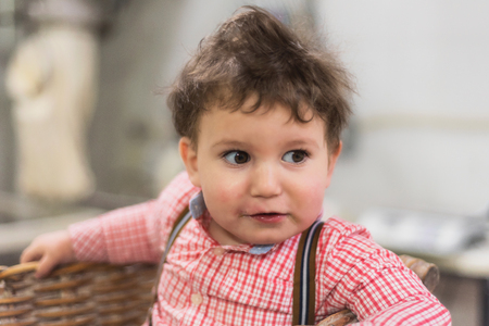 Portrait of a cute baby inside a basket in the bakeryの写真素材