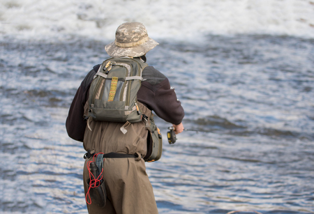 Young man flyfishing on the riverの写真素材