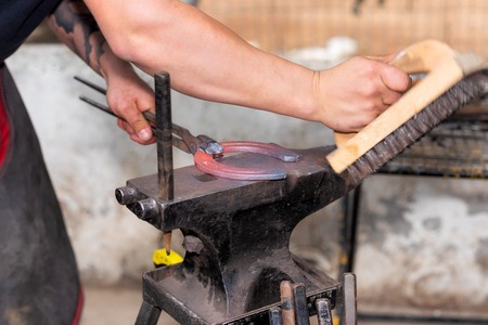 Blacksmith working on the anvil, making a horseshoe.