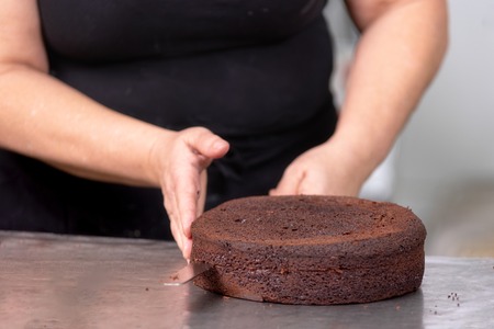 Professional confectioner making a delicious cake in the pastry shop.の写真素材