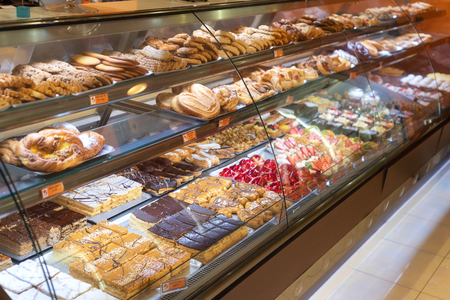 Different types of delicious cakes in pastry shop showcase.の写真素材
