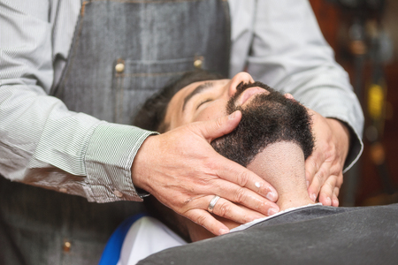 Hair stylist applying after shaving lotion at barber shop.の写真素材