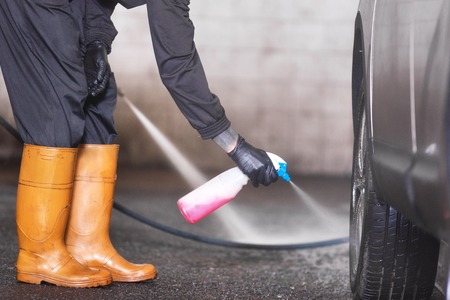 Professional car washer cleaning alloy wheels.の写真素材