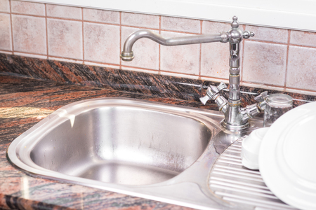 The Clean dishes are drying, on rustic kitchen metal sink.の写真素材