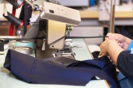 Woman tailor working on sewing machine. Hands. close up. Tailoring. Details.の写真素材