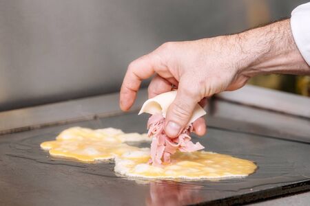 Chef cooking delicious Omelette with ham and cheese.の写真素材