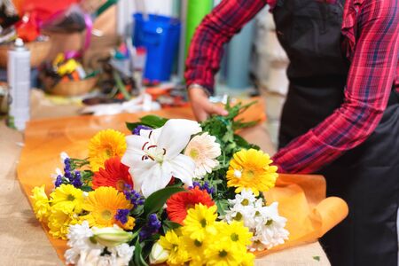 Florist at work. Woman hands making beautiful bouquet of flowers.の写真素材
