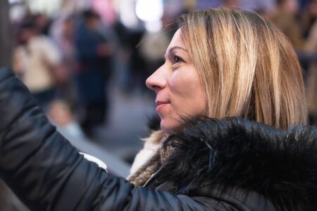 Young blond pretty woman portrait taking a selfie at city night.