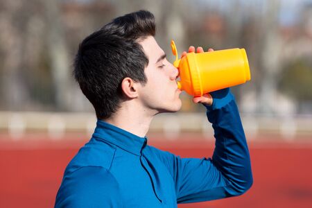 Athlete drinking water on a running track.の写真素材