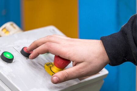 Hand pressing the red emergency button or stop button for industrial machine, Emergency Stop for...