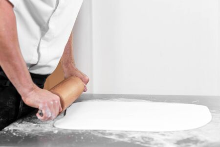 Woman using rolling pin preparing royal icing for cake decorating, hands detail.の写真素材