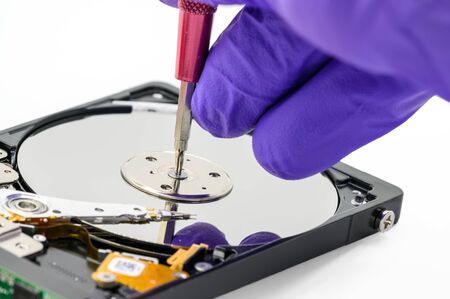 Close up of technician repairing hard disk drive by screwdriver in the lab. the concept of data,...