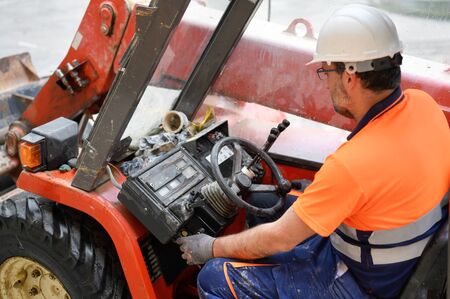 Construction worker starting the excavator machine.