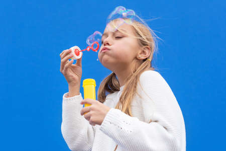 Funny girl blowing soap bubblesの写真素材
