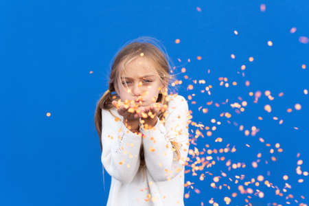 Satisfied girl smiling in flying confettiの写真素材
