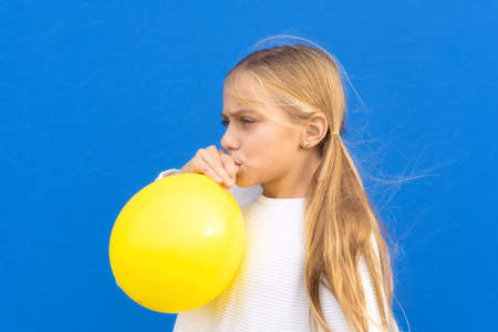 Close up photo of nice pretty lovely girl inflate ballon have free time positive cheerful funny girl isolated on blue colorful backgroundの写真素材