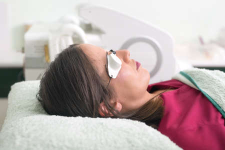 woman lying with protection glasses in beauty salon.