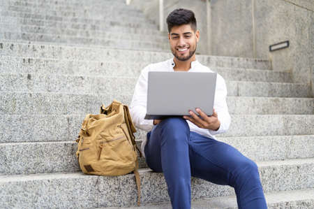 handsome young man working with laptop on stairsの写真素材