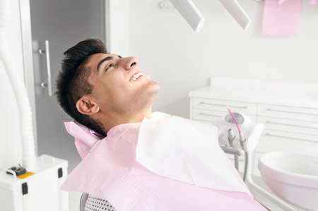 Portrait of happy patient in dental chair.の写真素材
