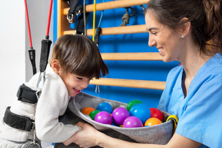 Cute kid with cerebral palsy doing musculoskeletal therapy in the hospital while laughing and having fun .の写真素材
