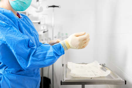 Coronavirus concept. Female nurse puts on protective cloths. Nurse wearing Personal protective equipment in the fight against Coronavirus disease .の写真素材