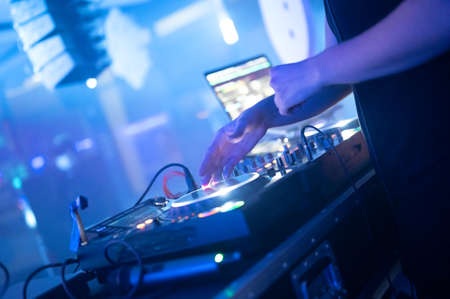 Dj mixing at party festival with light and smoke in background - Summer nightlife view of disco club...