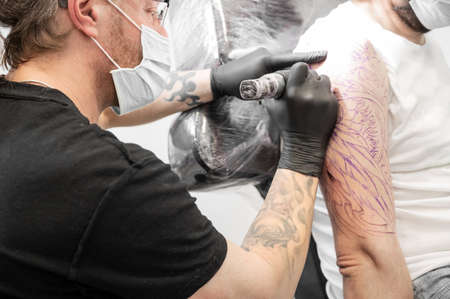 Salon tattoo. Close up of a Tattoo artist working. Tattoo artist make tattoo at the studio. High quality photography.の写真素材