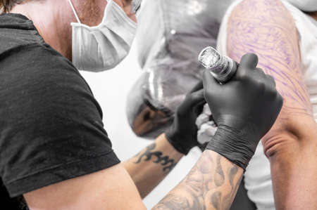 Tattoo artist making tattoo at the studioの写真素材