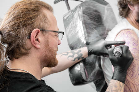 Salon tattoo. Close up of a Tattoo artist working. Tattoo artist make tattoo at the studio.の写真素材