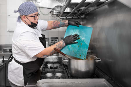 Side view of female chef working in commercial kitchenの写真素材