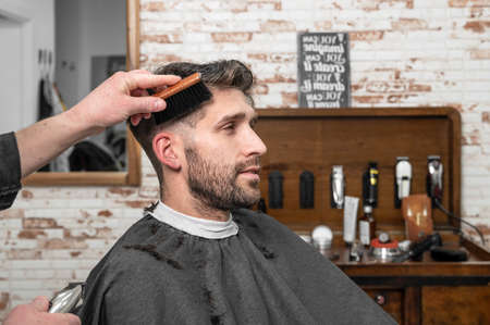 Shot of a barber using a brush on his clients beardの写真素材