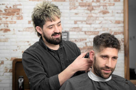 Closeup of happy man getting an haircut, in hair salon. High quality photoの写真素材
