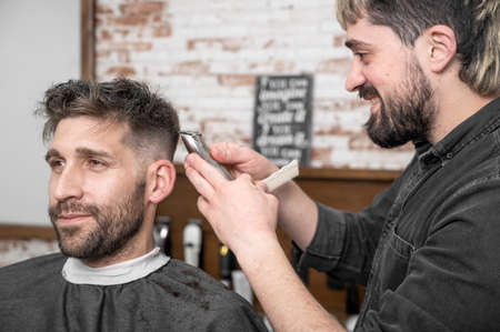 Closeup of happy man getting an haircut, in hair salon. High quality photoの写真素材