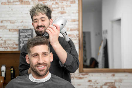 Barber drying hair of customerの写真素材