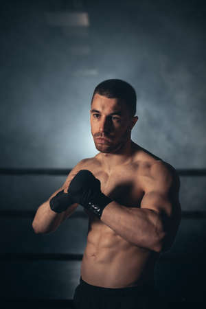 Boxer, man posing in bandage on boxing ring. Fitness and boxing concept.の写真素材