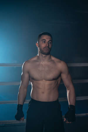 Boxer, man posing in bandage on boxing ring. Fitness and boxing concept.の写真素材