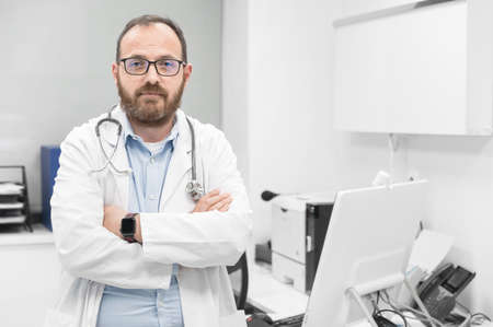 Portrait of confident doctor crossing hands and smiling at camera.の写真素材