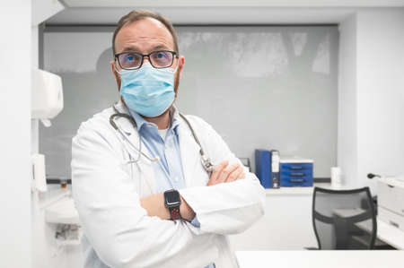 Professional medical doctor working in hospital office in protective face mask.の写真素材