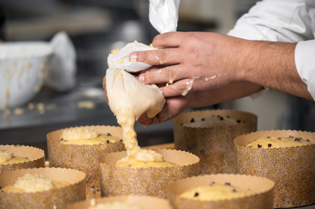 Confectioner topping panettone cakes with piping bag glazed sweet fillingの写真素材
