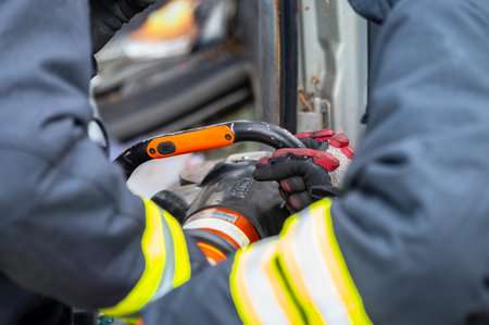 Firefighters using hydraulic tools during a rescue operation training. Rescuers unlock the passenger...