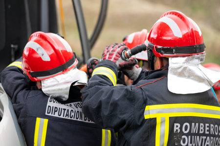 Firefighters using hydraulic tools during a rescue operation training. Rescuers unlock the passenger in car after accident.の写真素材