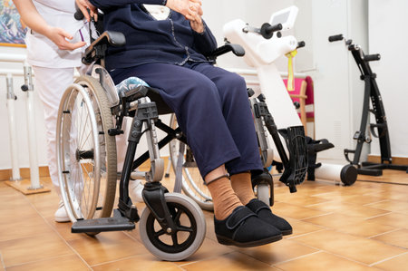 Doctor working with senior woman patient on wheelchair, clinics specialist at work, rehabilitation physiotherapy, unrecognizable elder womanの写真素材