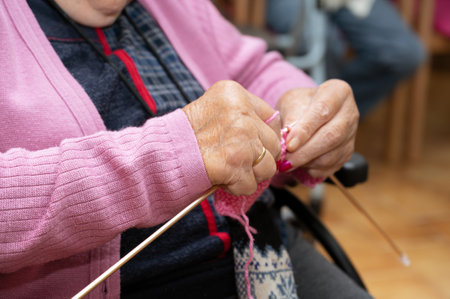 Elderly woman crocheting in a handicraft course as a hobby or occupational therapy at nursing home.の写真素材