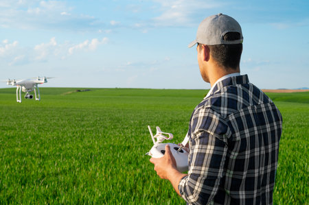 Modern Technologies in Agriculture. Farmer flying a drone over a young wheat field.