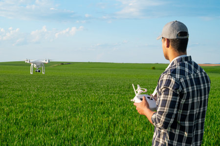 Modern Technologies in Agriculture. Farmer flying a drone over a young wheat field.