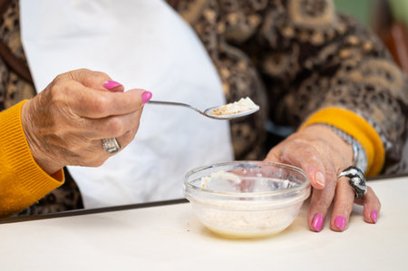 Close up of an elderly woman having lunch at retirement home.の写真素材