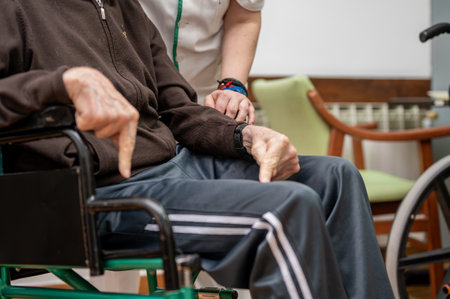 Caregiver assisting elderly man in dining room at nursing home.の写真素材