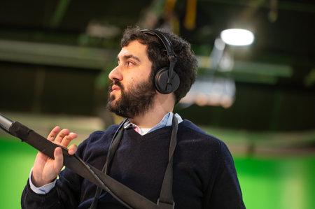 Boom microphone operator testing sound at TV studio.