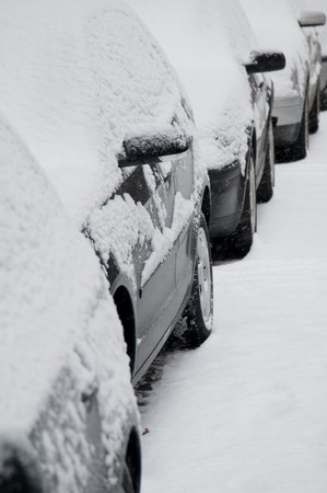Bunch of snow covered cars  standing in a rowの写真素材